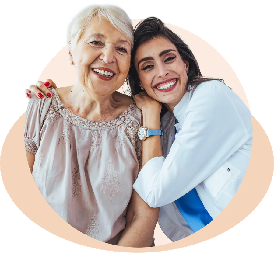A smiling older patient embracing her clinician